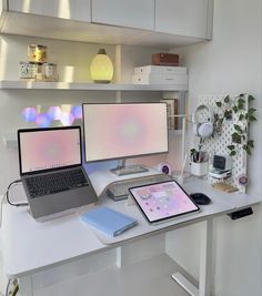 a desk with two laptops and a desktop computer on it