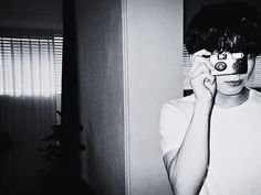 a young boy holding a camera up to his face