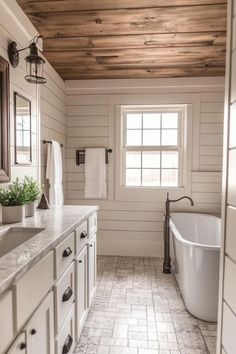 a bathroom with a tub, sink and window in it's center wall that has wood paneling on the ceiling