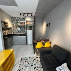 a living room filled with furniture next to a kitchen