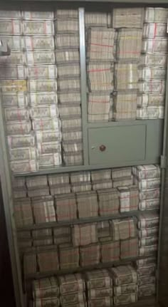 stacks of boxes stacked on top of each other in a room with a door open