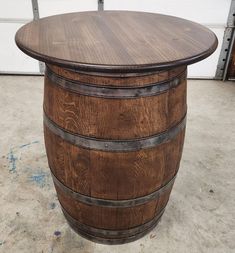 a wooden barrel table sitting on top of a cement floor