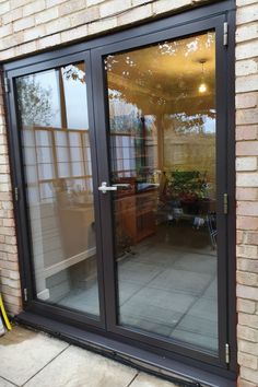 Newly fitted slimline black double glazed aluminium french doors leading out on to stone patio in Buckinghamshire. View into dining room with wooden dresser. Brown Interior Doors, Screened Deck, Kitchen Patio Doors, Black French Doors, Modern Patio Doors, Double Patio Doors