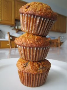 three muffins stacked on top of each other on a plate in a kitchen