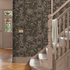 the stairs in this house are decorated with floral wallpaper and stained glass window panels