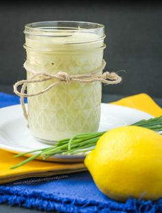 a lemon sitting on top of a plate next to a jar