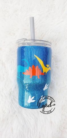 a blue tumbler with an orange and yellow bird on it