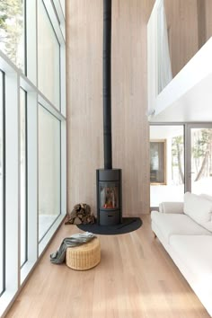 a living room with a couch and a wood stove in the middle of it's floor