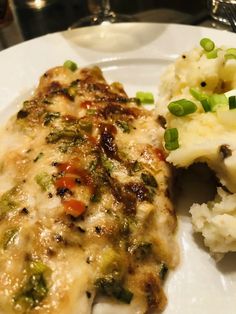 a white plate topped with meat covered in gravy and veggies