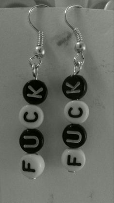 two black and white earrings with the word eq spelled in letters that spell out