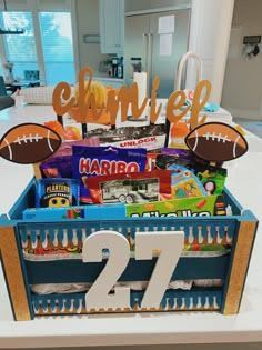 a football themed centerpiece with the number twenty seven in front of it and some candy