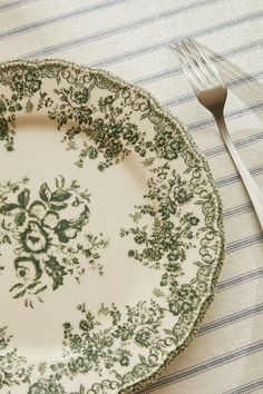 a white and green plate sitting on top of a table next to a knife and fork