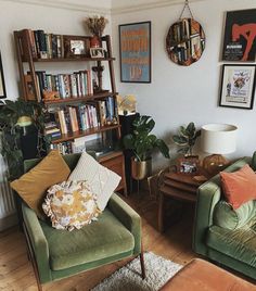 a living room filled with green couches and bookshelves next to each other