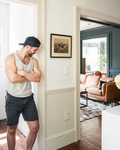 a man leaning against the wall in his living room