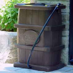 a hose is attached to the side of a wooden barrel with a window in the background