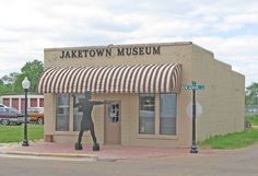 a small building with a statue in front of it