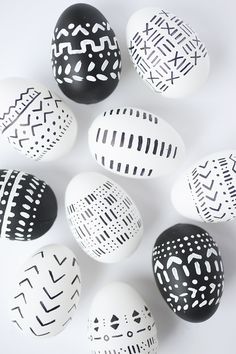 black and white painted easter eggs arranged in a circle on a white surface with one egg facing the camera