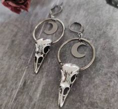 Crow, magpie, black bird, raven skull earrings made in silvertoned Zinc Alloy (nickel free) with a self contained closure. Jewelry Care Tips: Avoid direct contact with perfumes, body lotions and other chemicals. Remove jewelry when bathing, showering or sleeping. Store jewelry in a cool dry place. Do not wear jewelry to the pool or beach. Style: Gothic, Goth, Wiccan, Punk, Occult, Hiphop, Rock, Street, Streetwear  Free shipping in the Continental US Crow Moon, Crow Skull, Creative Women, Raven Skull, Crescent Moon Earrings, Witch Jewelry, Skull Halloween, Classic Earrings, Skull Pendant