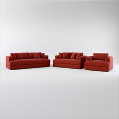 three red couches and two chairs in an empty room