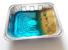 a tin container filled with blue and yellow liquid