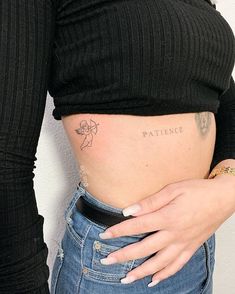 a woman's stomach with the word patience tattooed on her lower belly and hand