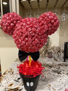 a mickey mouse head made out of candy bar wrappers in a pot on top of a counter