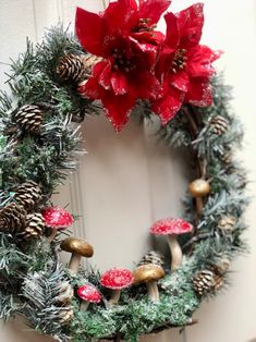 a wreath decorated with pine cones and poinsettis