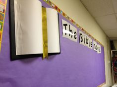 a bulletin board with the word the bible on it and a yellow ribbon tied to it