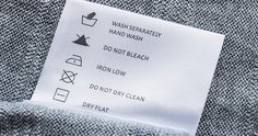 a label on the back of a gray sweater that says, wash separate hand wash don'tleash iron low not dry clean dryhat