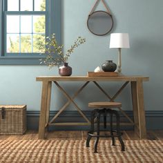 a room with a table, lamp and basket on the floor in front of it