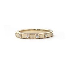 a gold wedding band with three diamonds on the inside and outside, set in 18k yellow gold