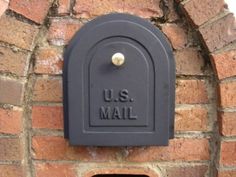 a mailbox mounted to the side of a brick wall that says u s mail