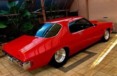 a red car parked in front of a garage