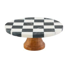 a black and white checkerboard cake plate on a wooden base with wood legs