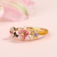 Transforming the iconic "Water Lilies" from Monet into an unexpected and artistic treasure, this beautifully detailed ring boasts charming lotuses in bright shades of enamel. The intricate flawless enamel work coupled with sparking stones, make this an eye-catching piece. Encapsulating peace and harmony, this intricately crafted ring looks beautiful worn alone or when layered in a stack. The stacking ring showcases the dreamlike play of light and shadow on the shimmering water surface. In Monet' Water Lily Jewelry, Shimmering Water, Lily Ring, Playful Jewelry, Dreamy Garden, Water Surface, Color Champagne, Detailed Ring, Funky Jewelry