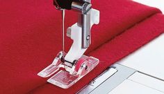 the sewing machine is being used to sew on red carpeted area with white trim