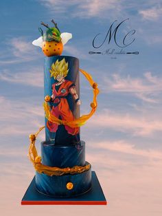 a dragon ball cake is on top of a blue stand with an orange ribbon around it