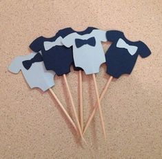 four little bow ties on top of toothpicks in the shape of an elephant