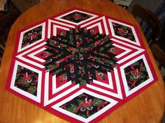 a quilted table topper sitting on top of a wooden table next to a chair