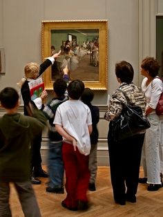 a group of children standing in front of a painting