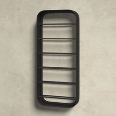 a black rack mounted to the side of a wall with three shelves on each side