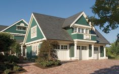 a large green house with white trim and windows