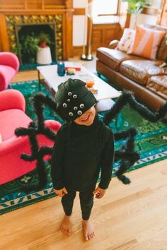 a little boy wearing a spider costume in the living room