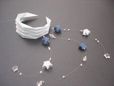 an origami star and other decorations on a gray surface with white paper attached to it