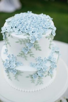 a wedding cake with blue flowers on it