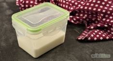 a plastic container sitting on top of a table next to a red and white cloth