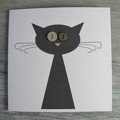 a card with a black cat's face and two buttons in the shape of a cat