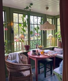 a living room filled with furniture and lots of windows next to a wooden dining table