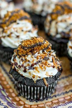 chocolate cupcakes with white frosting and sprinkles on a plate