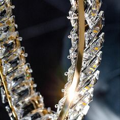 a crystal chandelier hanging from the ceiling with light shining on it's sides